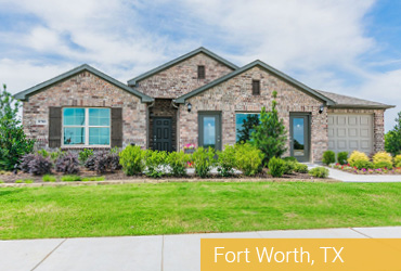 A brick home with green lawn and paved walkway.